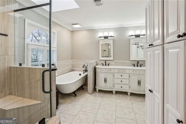 bathroom featuring tile patterned floors, crown molding, separate shower and tub, tile walls, and vanity