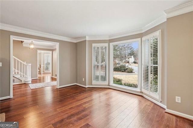 unfurnished room featuring dark wood-type flooring and ornamental molding