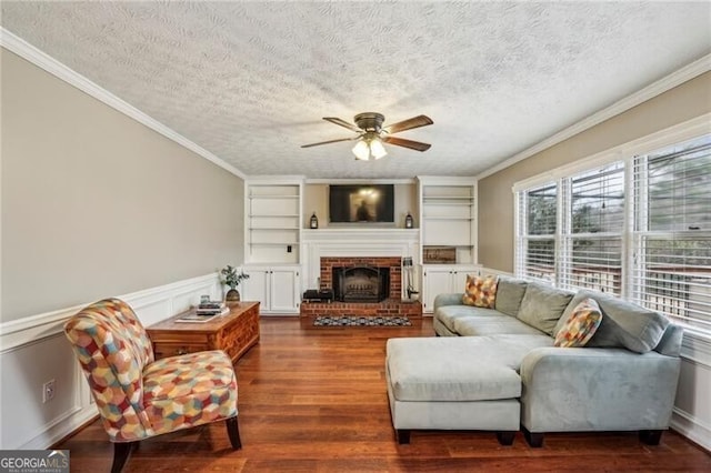 living room with dark hardwood / wood-style flooring, crown molding, a fireplace, and a textured ceiling