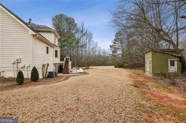 view of yard featuring central AC and a storage unit