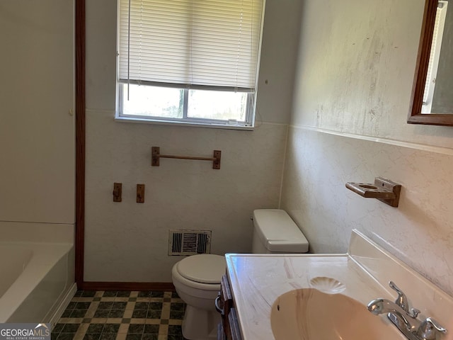 bathroom with vanity, toilet, and a washtub