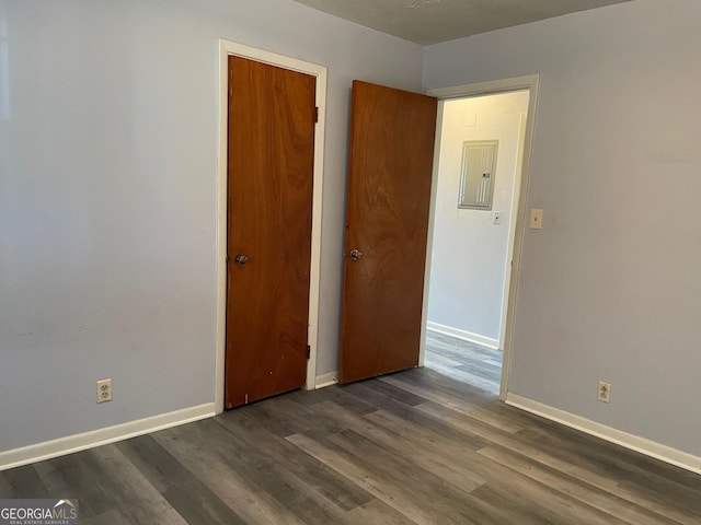 spare room with dark wood-type flooring and electric panel