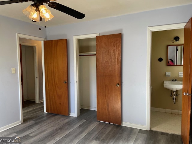 bedroom with dark hardwood / wood-style flooring, sink, connected bathroom, and a closet