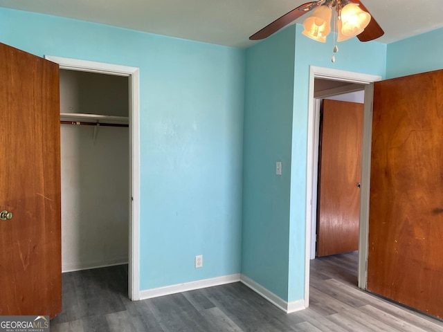 unfurnished bedroom with ceiling fan, wood-type flooring, and a closet