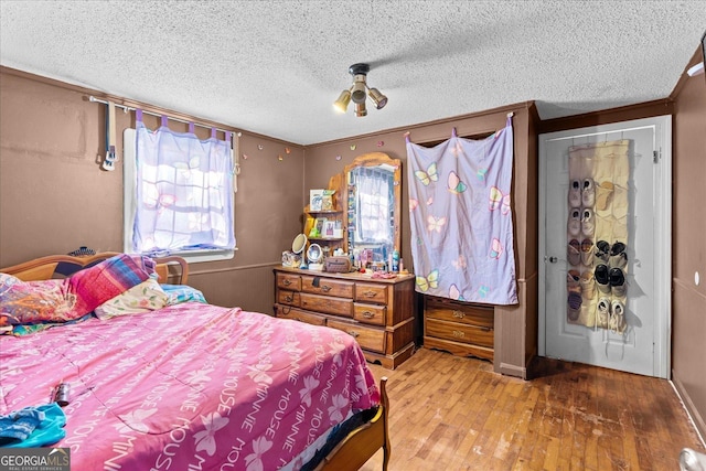 bedroom with hardwood / wood-style flooring and a textured ceiling