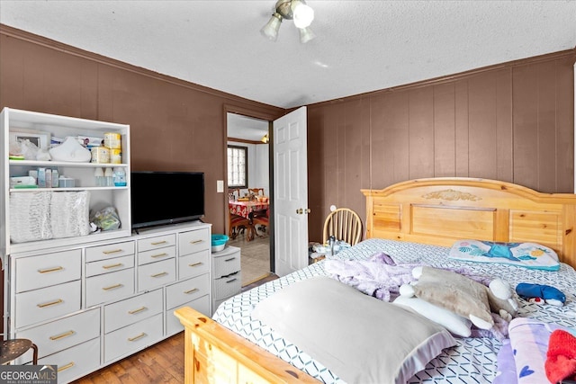 bedroom featuring light hardwood / wood-style floors and a textured ceiling