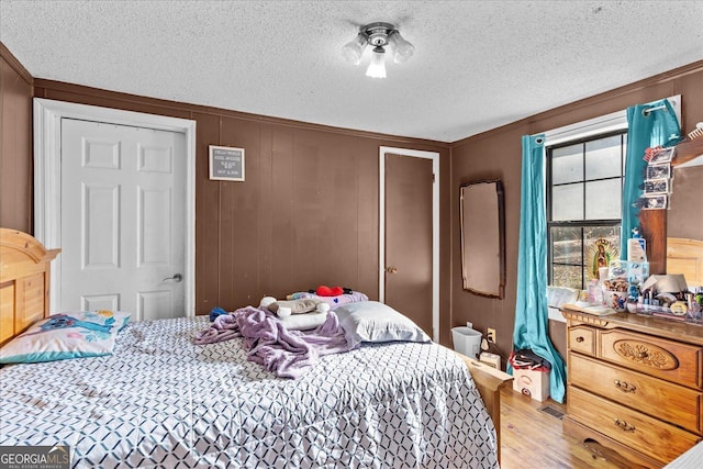 bedroom with wood-type flooring and a textured ceiling