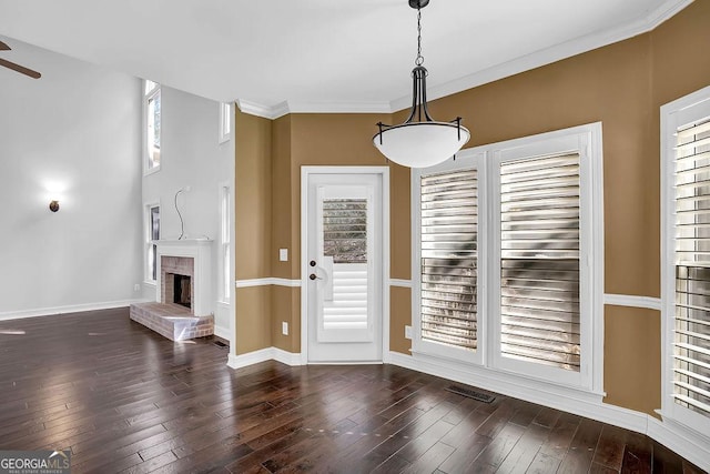 interior space featuring crown molding, a fireplace, and dark hardwood / wood-style floors