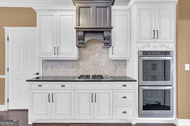 kitchen featuring dark wood-type flooring, appliances with stainless steel finishes, decorative backsplash, and white cabinets