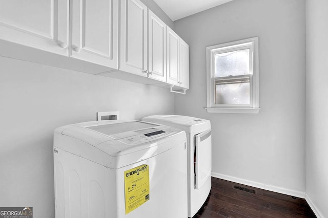 laundry area featuring dark hardwood / wood-style floors, cabinets, and washing machine and clothes dryer