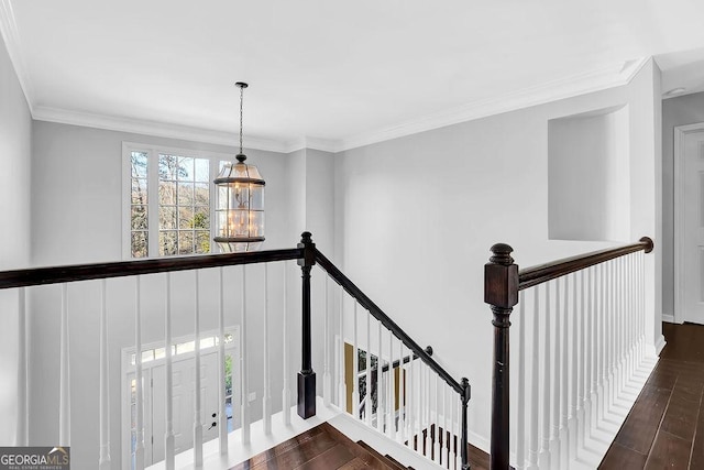 stairway with crown molding, wood-type flooring, and a chandelier