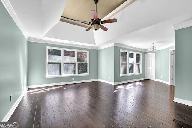 unfurnished room featuring a tray ceiling, crown molding, dark wood-type flooring, and ceiling fan with notable chandelier