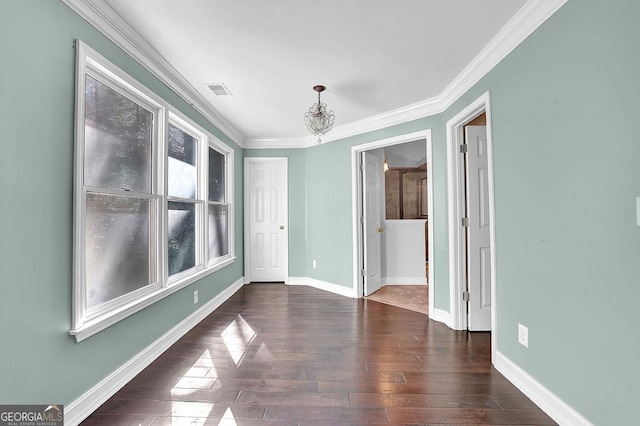 unfurnished room with crown molding, dark hardwood / wood-style floors, and an inviting chandelier