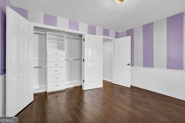 unfurnished bedroom featuring dark hardwood / wood-style flooring and a closet