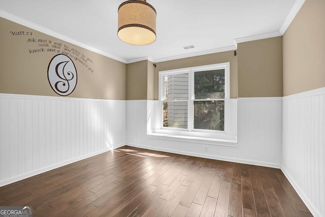 spare room featuring dark wood-type flooring and ornamental molding