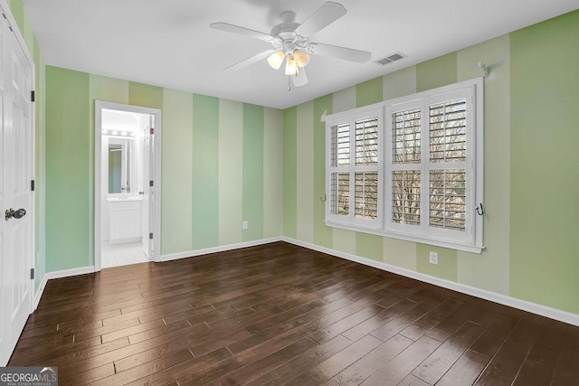 empty room featuring dark wood-type flooring and ceiling fan