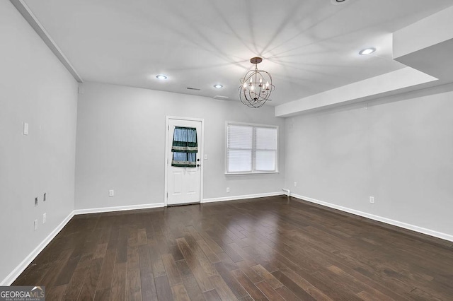 unfurnished room with dark wood-type flooring and a notable chandelier