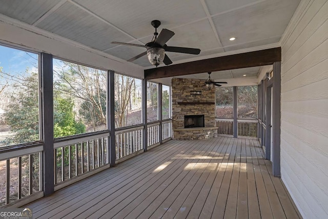 unfurnished sunroom with ceiling fan and beamed ceiling