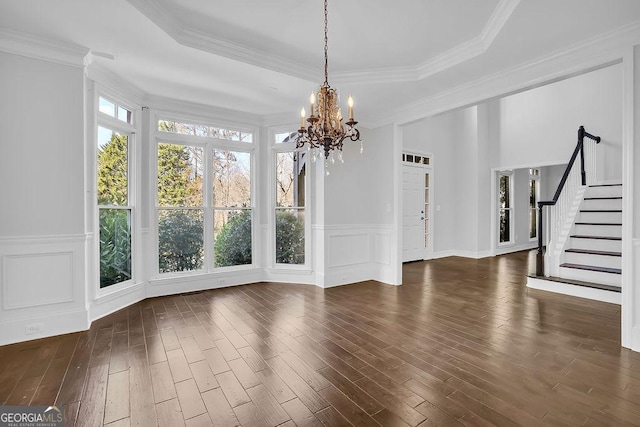 interior space featuring crown molding, dark hardwood / wood-style floors, a raised ceiling, and a chandelier