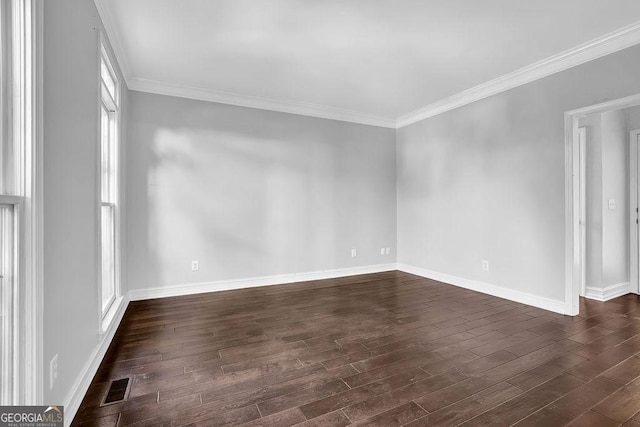 empty room featuring ornamental molding and dark wood-type flooring