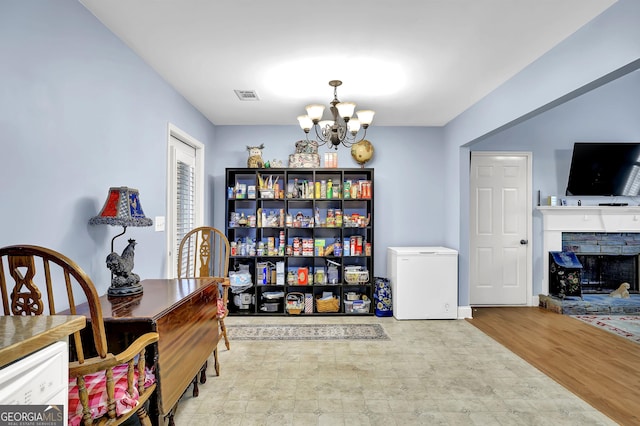 interior space featuring an inviting chandelier, a fireplace, and visible vents