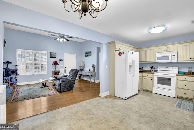 kitchen featuring light floors, cream cabinetry, and white appliances