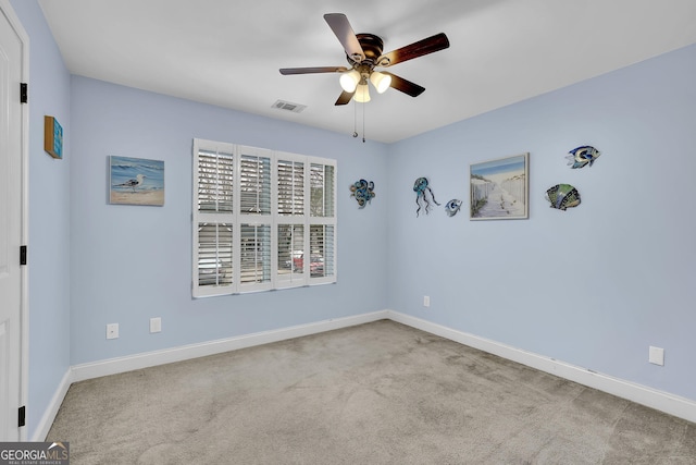 carpeted empty room with ceiling fan, visible vents, and baseboards