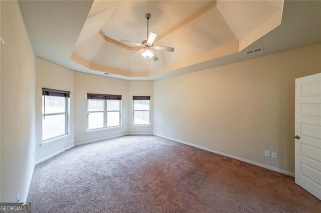 unfurnished room with carpet floors, a raised ceiling, and ceiling fan