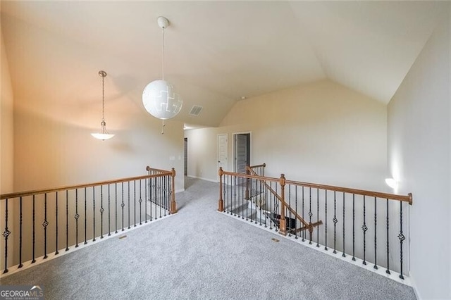 corridor with vaulted ceiling and carpet flooring