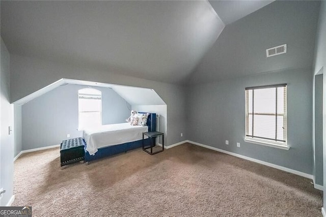 unfurnished bedroom featuring lofted ceiling and carpet