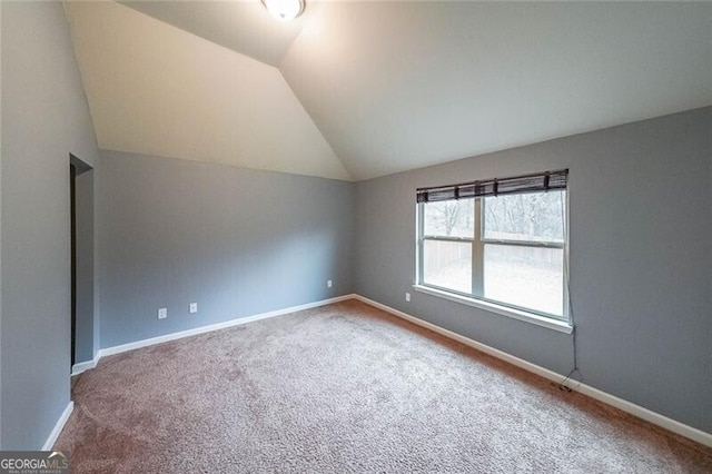 spare room with vaulted ceiling and carpet