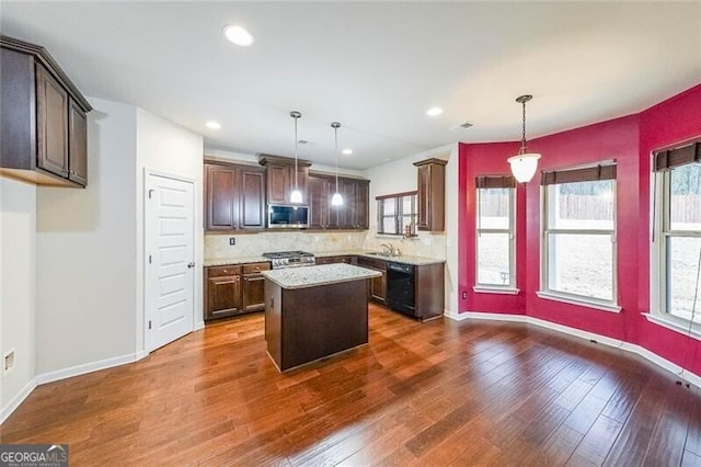 kitchen with pendant lighting, stainless steel appliances, dark hardwood / wood-style floors, and a center island