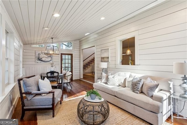 living room with hardwood / wood-style floors, wood ceiling, and wood walls