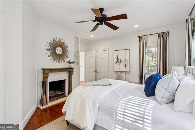 bedroom featuring hardwood / wood-style flooring, ceiling fan, and ornamental molding