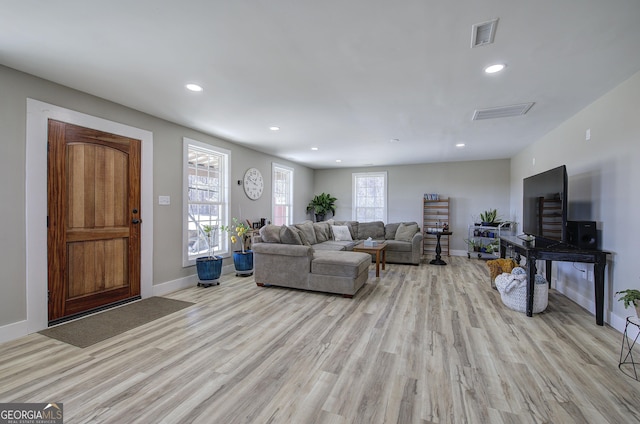 living room with recessed lighting, baseboards, visible vents, and light wood finished floors