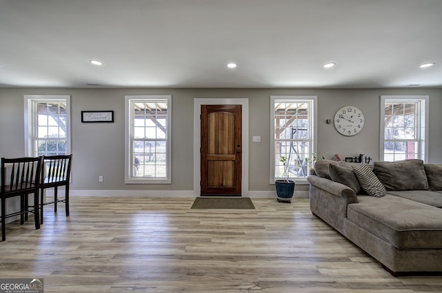 living area with baseboards, light wood-style flooring, and recessed lighting