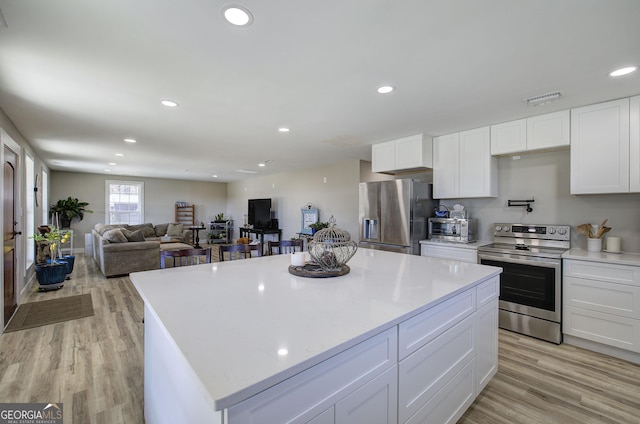 kitchen featuring light wood-type flooring, white cabinetry, stainless steel appliances, and recessed lighting