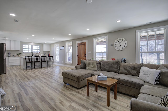 living area featuring light wood-style floors, visible vents, and recessed lighting