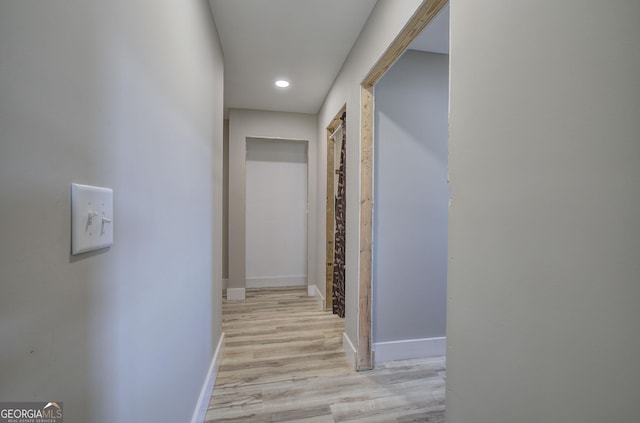 hallway featuring recessed lighting, light wood-style flooring, and baseboards