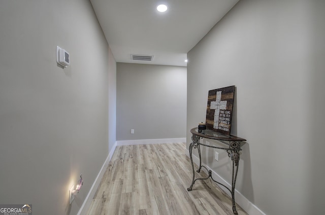 corridor with light wood-style flooring, recessed lighting, visible vents, and baseboards