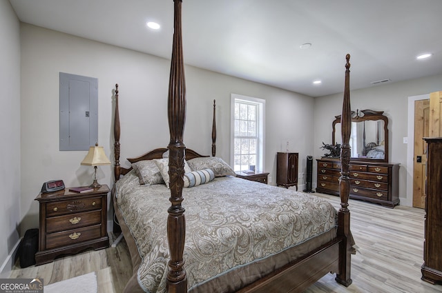 bedroom with light wood finished floors, electric panel, visible vents, and recessed lighting