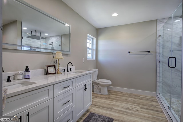 full bath with baseboards, wood finished floors, a sink, and a shower stall