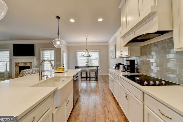 kitchen with sink, premium range hood, hanging light fixtures, black electric cooktop, and stainless steel dishwasher