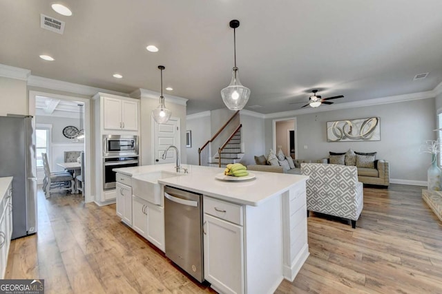 kitchen with sink, decorative light fixtures, an island with sink, stainless steel appliances, and white cabinets