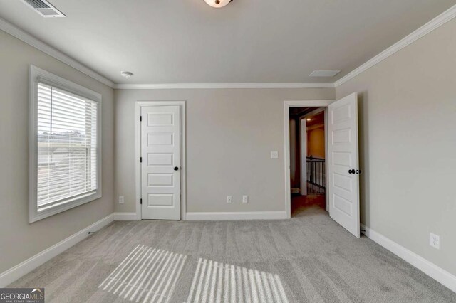 unfurnished bedroom featuring ornamental molding and light carpet