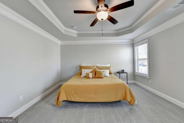 bedroom with crown molding, a tray ceiling, ceiling fan, and carpet flooring