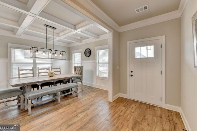 entryway with beamed ceiling, ornamental molding, coffered ceiling, and light wood-type flooring