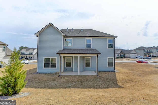 rear view of house with a yard and a patio