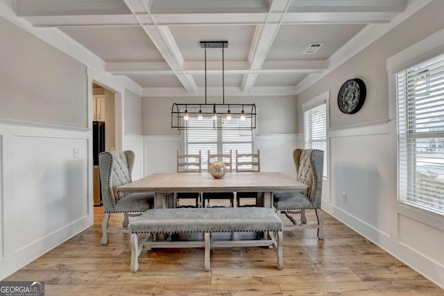 dining area with coffered ceiling, light hardwood / wood-style floors, and beamed ceiling