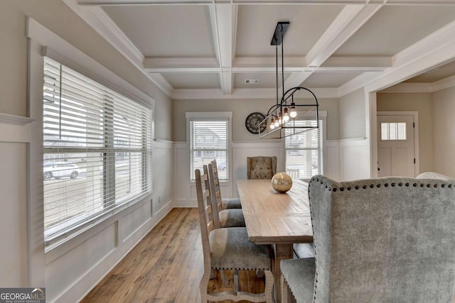 dining area featuring coffered ceiling, an inviting chandelier, wood-type flooring, ornamental molding, and beamed ceiling